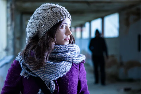 Image of a woman looking over her shoulder, symbolizing the fear and anxiety experienced by victims of stalking. Alt tag: Stalking Protective Order Requirements Explained.. What are the Requirements for Getting a Stalking Protective Order?