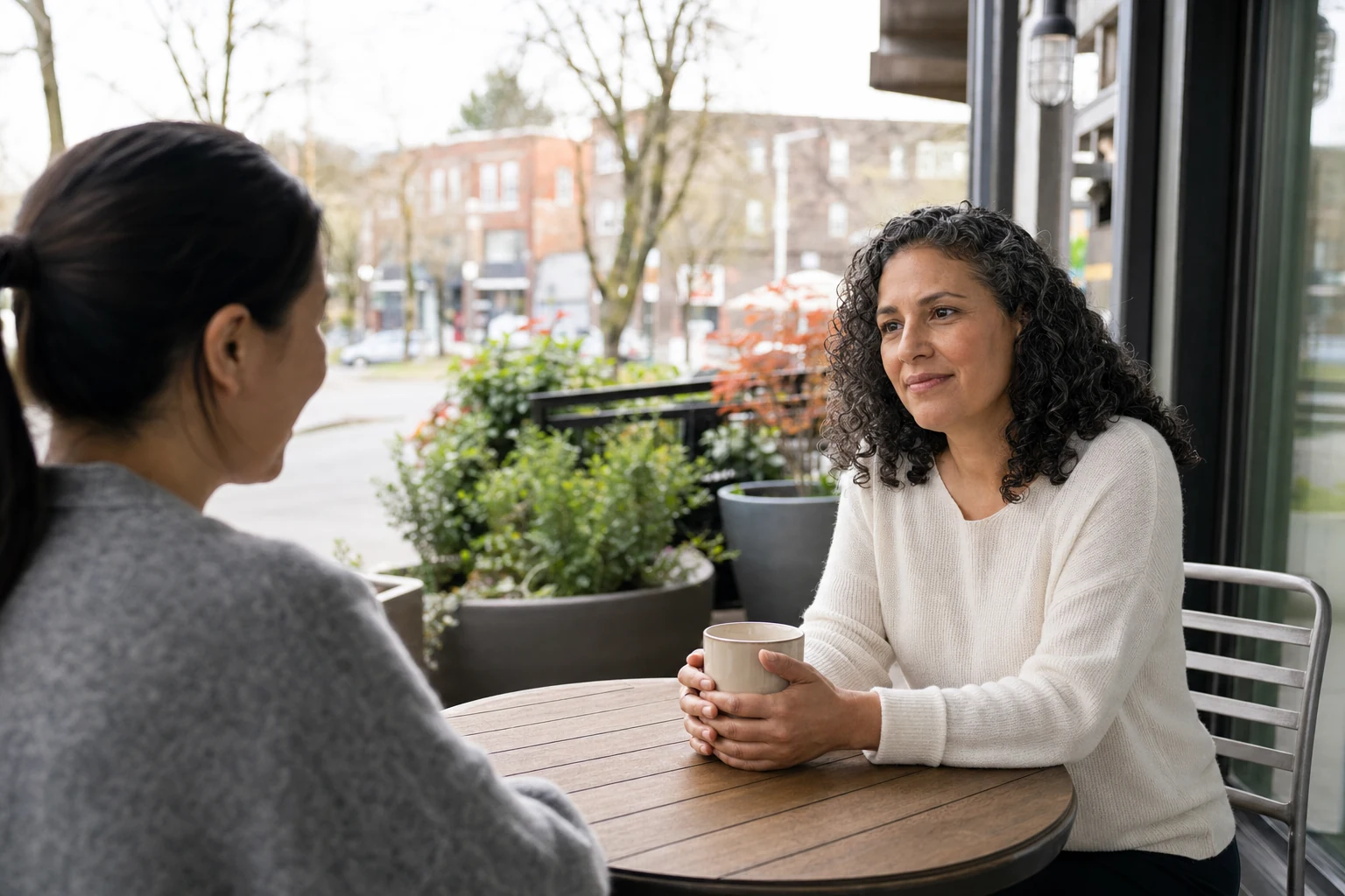 An image of a diverse group of people sitting around a table in a modern office setting, engaged in discussion. The individuals include both men and women, representing various ages and ethnicities. They appear to be reviewing documents, with one person p